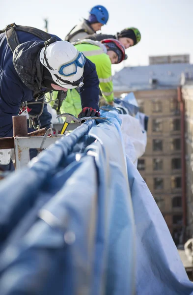 Escaladores industriales trabajando en el techo del edificio — Foto de Stock