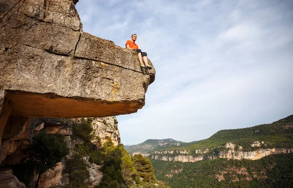 Pensive man sitting on edge of cliff — Stock Photo, Image