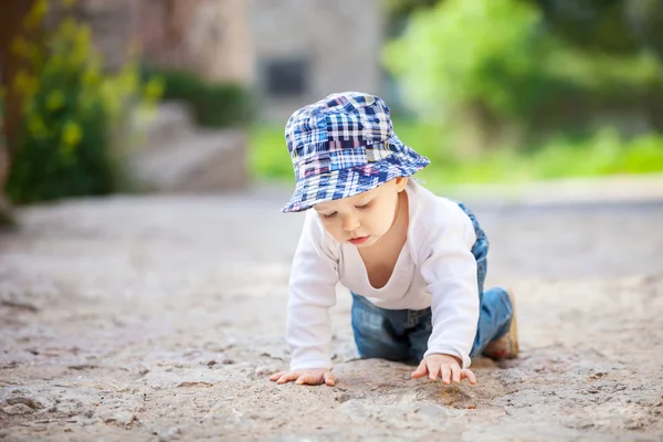 Petit garçon rampant sur un trottoir pavé de pierre — Photo