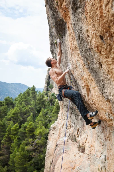 Männlicher Bergsteiger auf anspruchsvoller Route an Klippe — Stockfoto