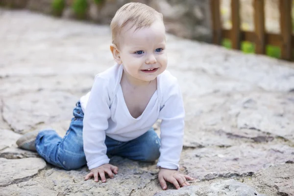 Lindo niño arrastrándose en la acera pavimentada de piedra —  Fotos de Stock