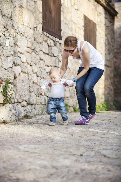 Bebek annesinin yardımıyla ilk adımlarını yapar — Stok fotoğraf