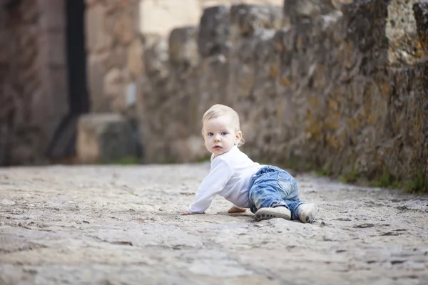 Малыш ползает по каменной мощеной тротуаре — стоковое фото