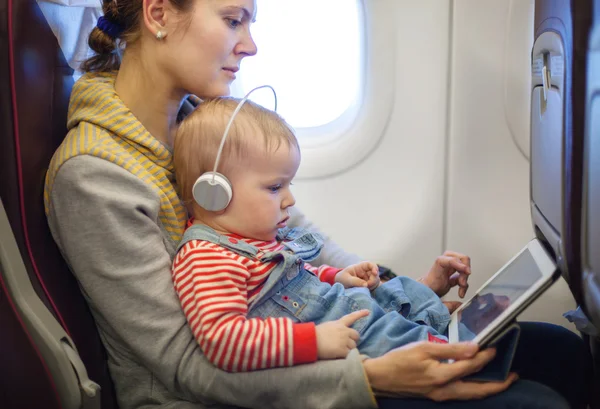 Mother and son using tablet on board of airplane — Stock Photo, Image