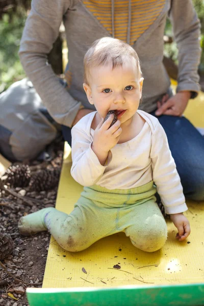 Little boy biting a cone, mother behind the boy — Stock Photo, Image