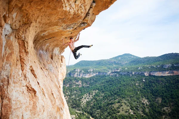 Mężczyzna rock alpinista na trudnej trasie na klifie — Zdjęcie stockowe