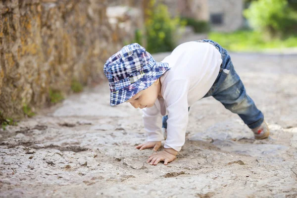 Ragazzino che striscia sul marciapiede lastricato di pietra — Foto Stock