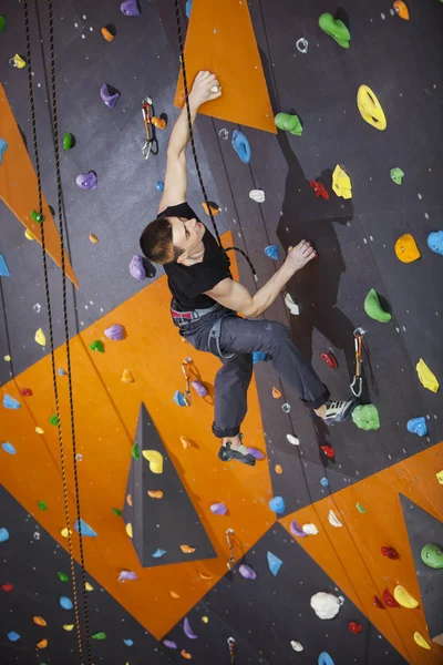 Homme pratiquant l'escalade en corde supérieure dans le gymnase d'escalade — Photo