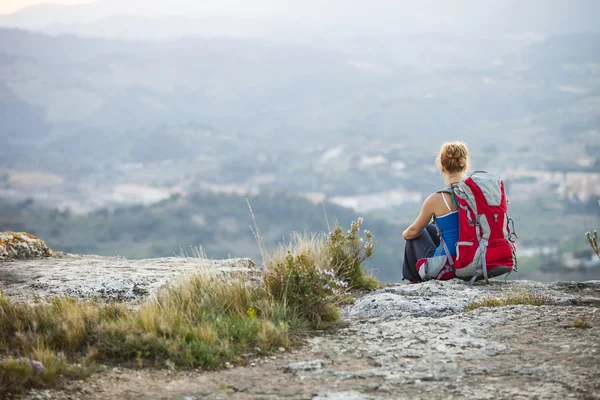 Turistické žena sedí na vrcholu hory — Stock fotografie
