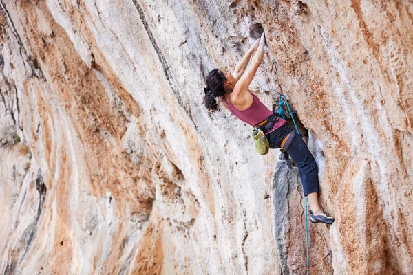 年轻女性攀岩在悬崖上 — 图库照片
