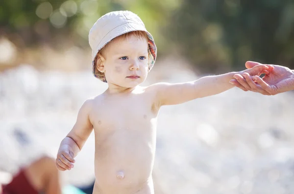 Bambino in cappello su una spiaggia — Foto Stock