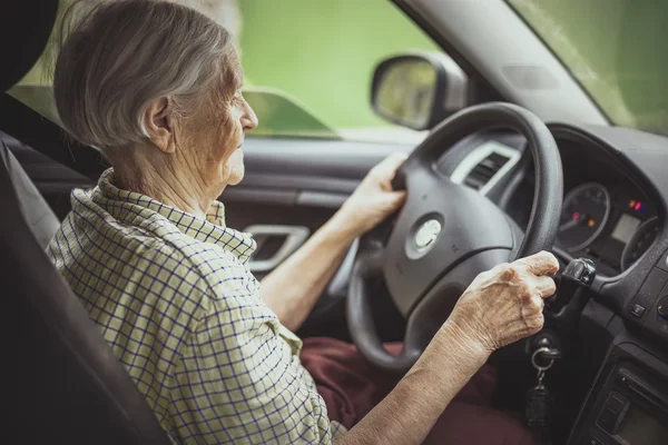 Seniorin fährt Auto — Stockfoto