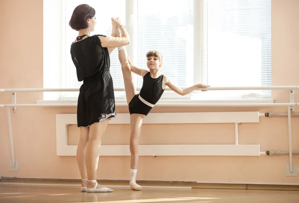 Ballet teacher adjusting leg position of ballerina — Stock Photo, Image