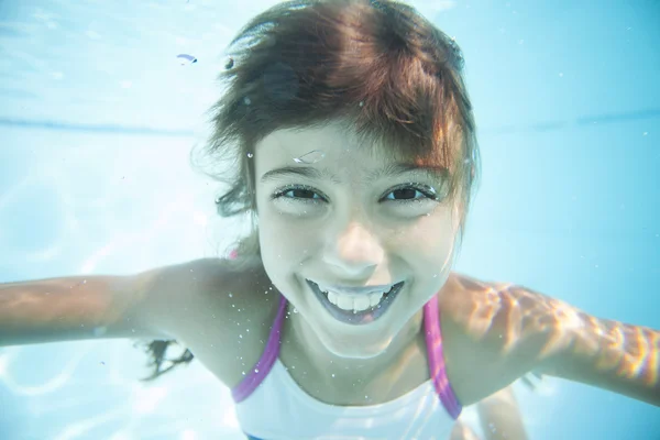 Menina nadando debaixo d 'água na piscina — Fotografia de Stock