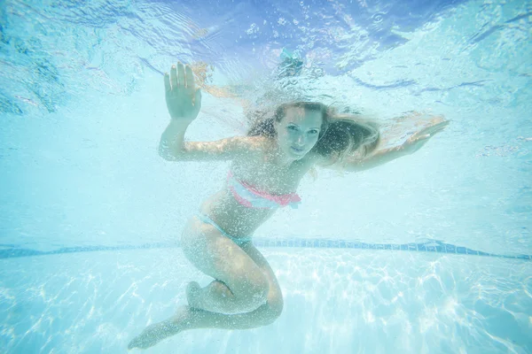 Mujer joven nadando bajo el agua en la piscina — Foto de Stock