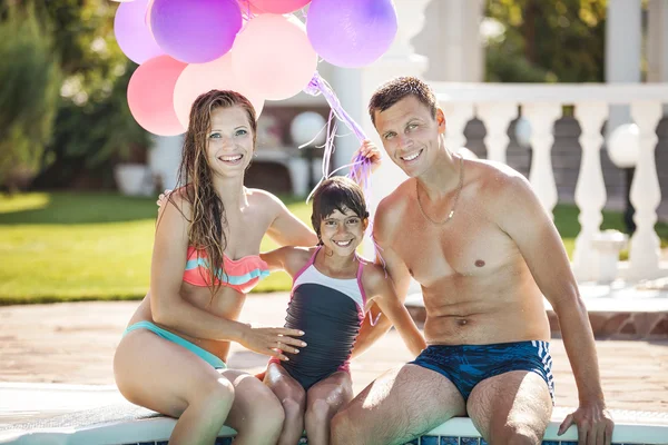 Familia feliz cerca de una piscina — Foto de Stock