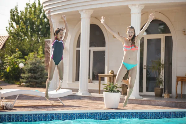 Madre e hija saltando a la piscina — Foto de Stock