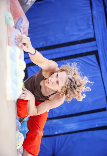 Жінка альпіністка на штучній скелелазній стіні — стокове фото