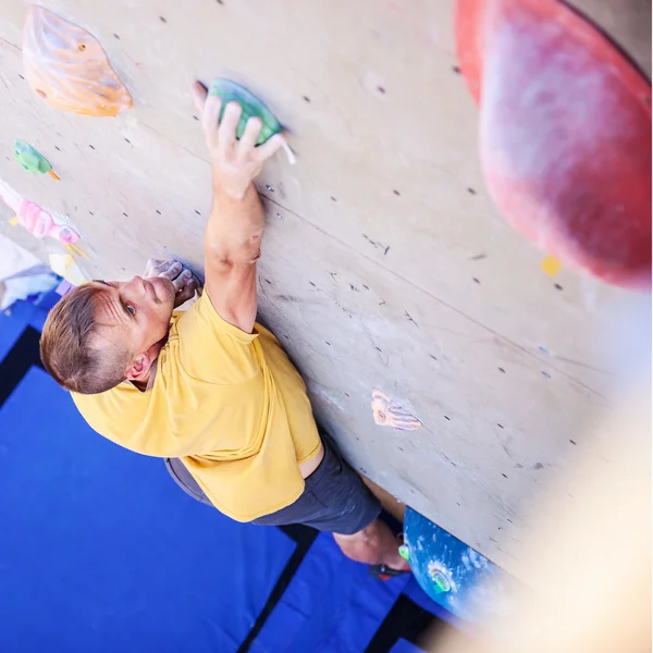 Homem alpinista na parede de escalada artificial — Fotografia de Stock