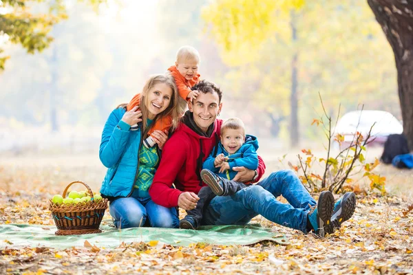 幸福的年轻家庭，在秋天的树林 — 图库照片