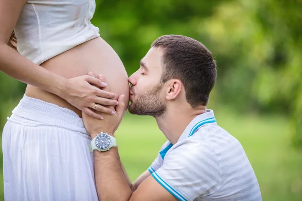 Man kissing his pregnant wife's belly — Stock Photo, Image