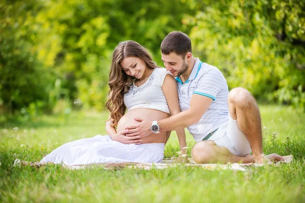 Pregnant woman with husband touching belly Stock Photo