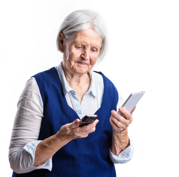 Woman choosing between cellphone and smartphone — Stock Photo, Image