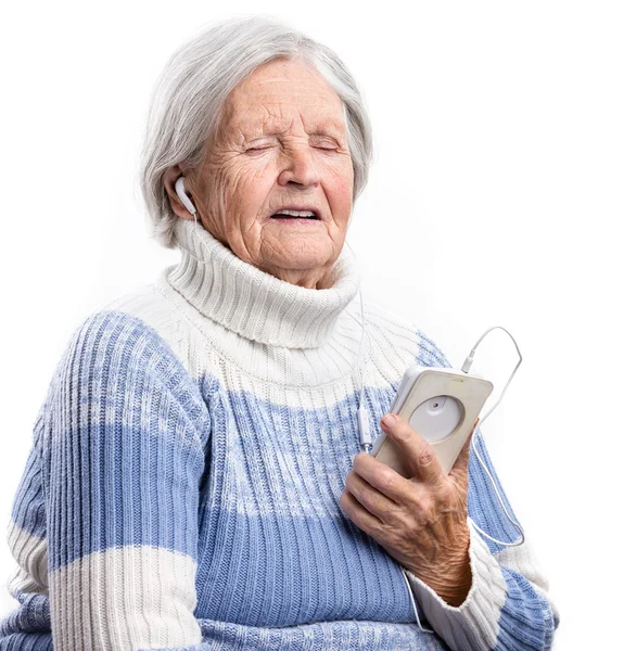 Senior woman listening to music and singing — Stock Photo, Image