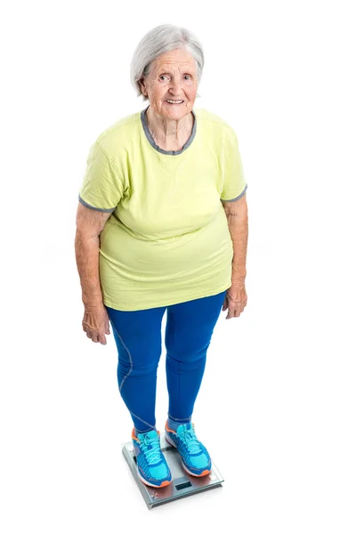 Senior woman weighing herself on scales — Stock Photo, Image