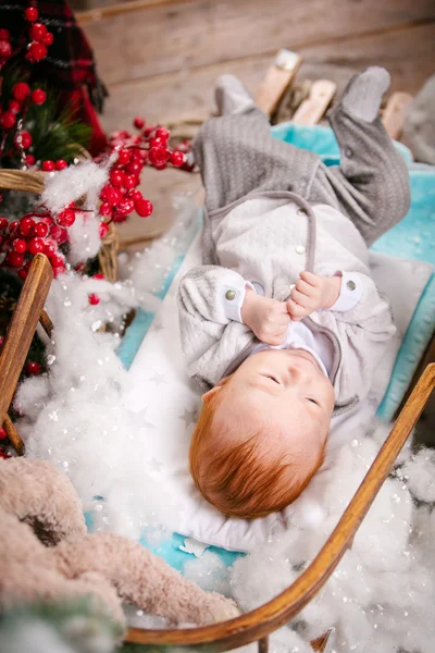 Roztomilý chlapeček, ležící na saních — Stock fotografie