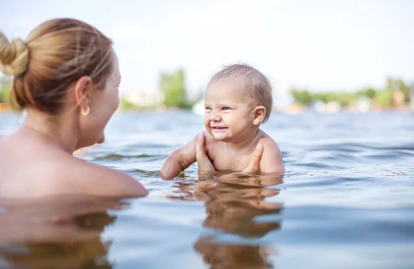 Woman and little son playing in water — Stock Photo, Image