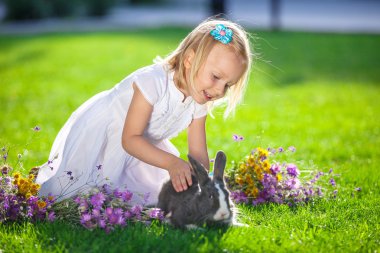Kız tavşanla oynuyor.