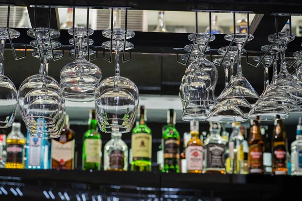 Vasos vacíos para vino por encima de un estante de bar, colgando para secar — Foto de Stock