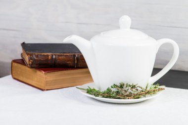 Yeşil Beyaz çaydanlık yaprakları bitki çayı ve eski kitaplar