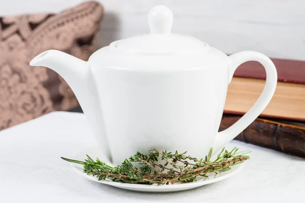 White teapot with green leaves herbal tea