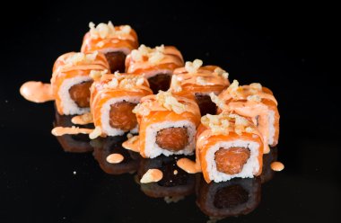 Yansıması ile siyah arka plan üzerinde suşi rulo ile Somon