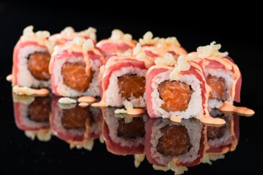 Tașõma ile siyah arka plan üzerinde suşi rulo somon ve ton balığı ile