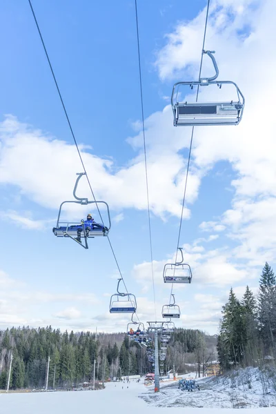 skiers ride the ski chair lift up