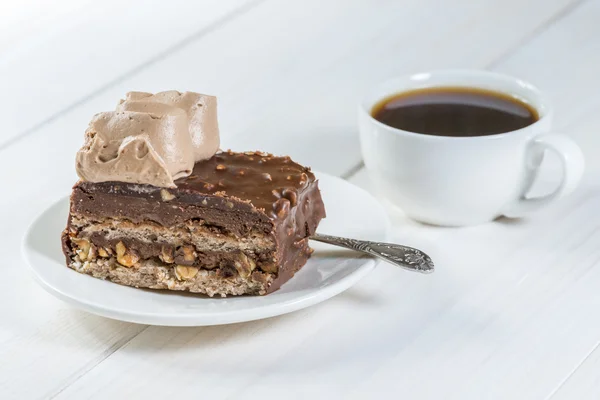 Piece of chocolate cake and cup of coffee on a background of whi — Stock Photo, Image