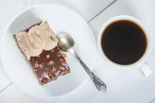 Piece of chocolate cake and cup of coffee on a background of whi — Stock Photo, Image