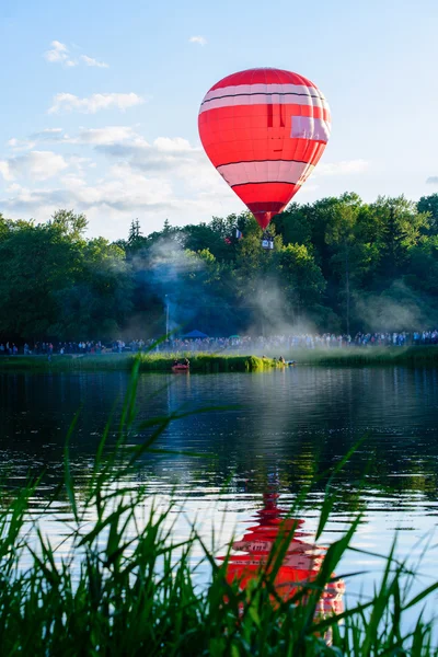 Red Hot air balloon with reflection in water, soft focus