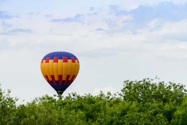 Flyg ballongflygning över träden på en bakgrund av moln — Stockfoto