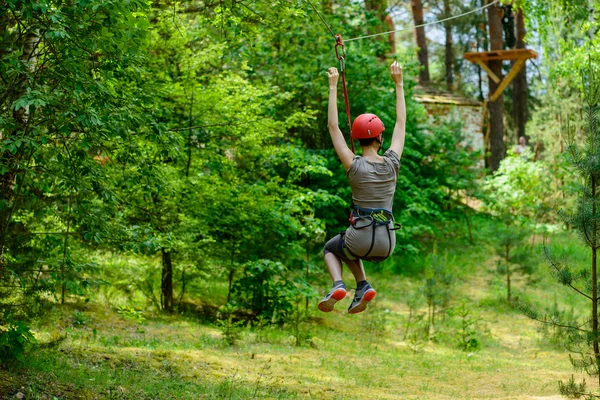 Junge Frau klettert im Abenteuer-Hochseilpark — Stockfoto