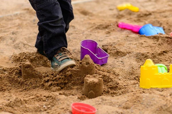 Brinquedos coloridos na caixa de areia em um dia ensolarado, profundidade rasa de fi — Fotografia de Stock