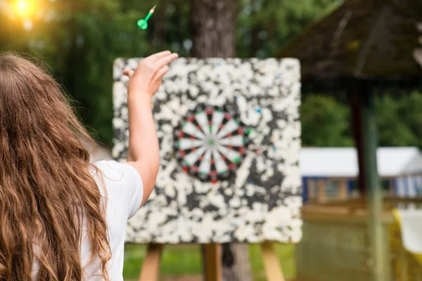 Menina jogando dardos, foco no curto prazo — Fotografia de Stock