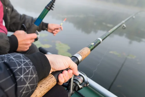 Close-shot de mãos humanas segurando uma vara de pesca em primeiro plano — Fotografia de Stock