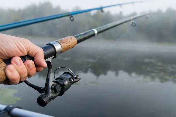 Vara de pesca na mão homem close-up, raso dof — Fotografia de Stock