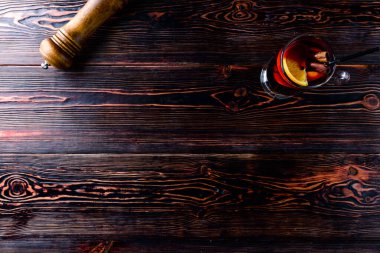 Ahşap arka planda sıcak şarap ve baharatlar.