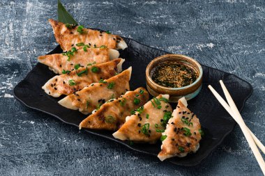 Geleneksel Asya tavası kızartılmış sos soslu gyoza köftesi, seramik tabakta et ve mantarlı japon gyoza köftesi.
