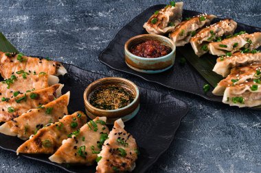 Geleneksel Asya tavası kızartılmış sos soslu gyoza köftesi, seramik tabakta et ve mantarlı japon gyoza köftesi.